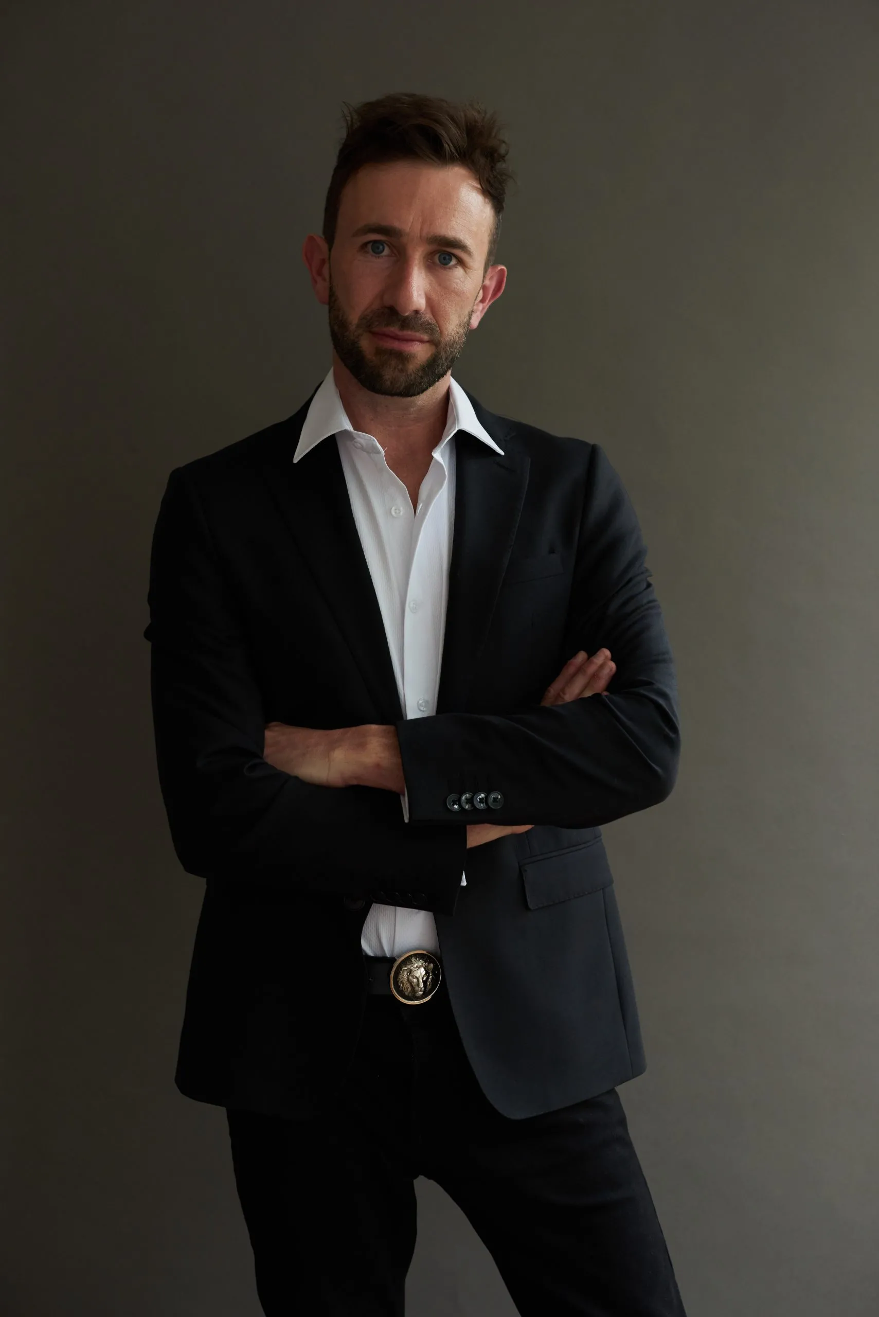 James-black-suit-folded-arms_-scaled